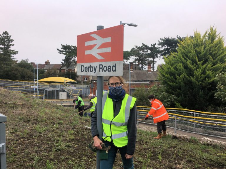 Volunteers prepare to sow wildflower seeds at Derby Road station