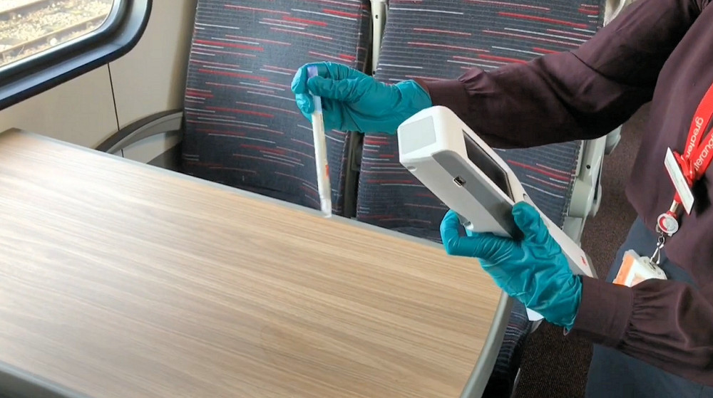 Hygiene monitor being used to test surfaces on a Greater Anglia train
