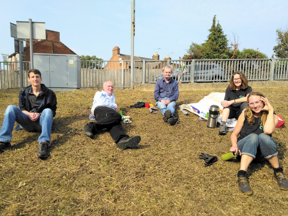 Volunteers take a break after clearing the wildflower patch at Derby Road station