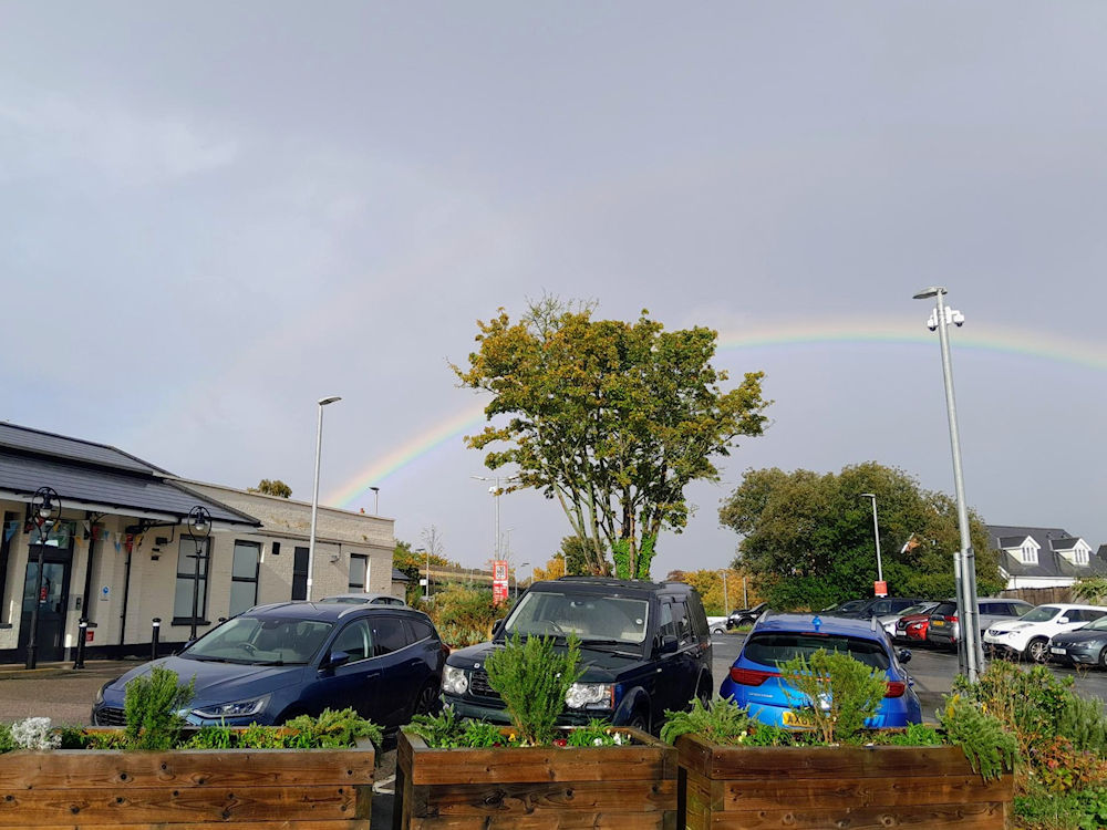 Newly installed flowers and a rainbow over Saxmundham Station Station 20 October 2025